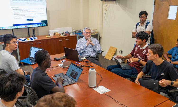 Ed Coyle leading a group of students at a table discussing his VIP course.