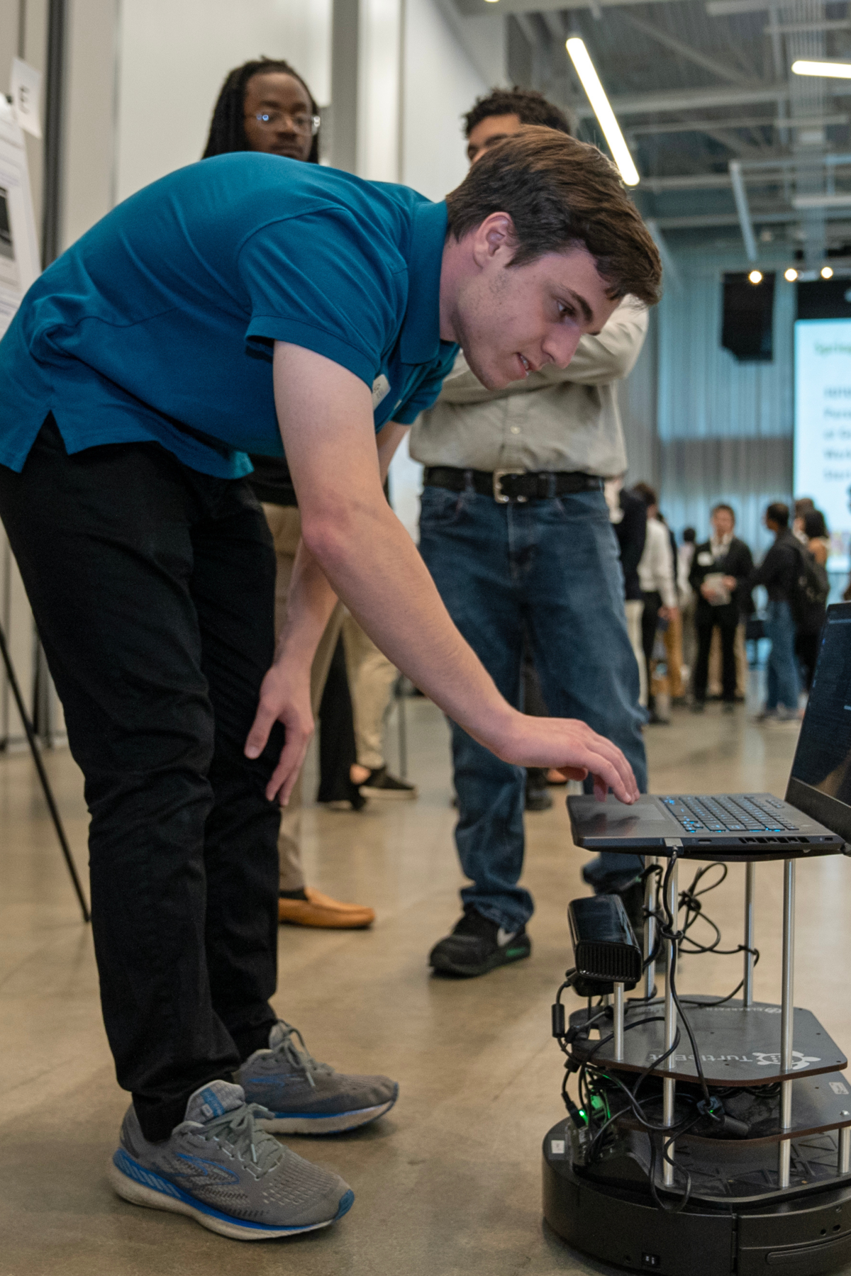  A student at the 2023 Opportunity Research Scholar's (ORS) Symposium demoing his group’s autonomous navigation research project. 