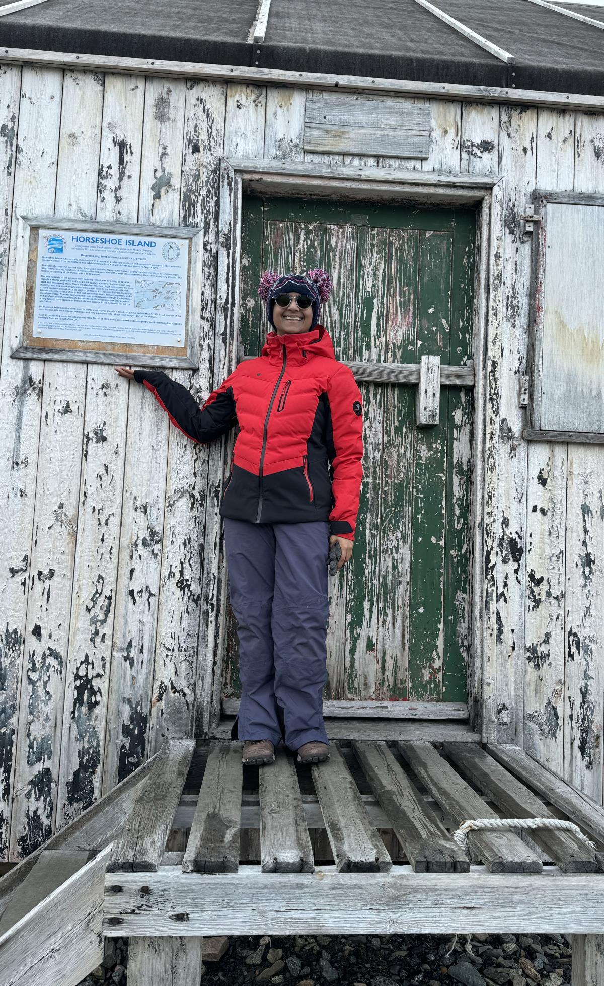 Shweta in front of original main building of an inactive British research base on the Horseshoe Island.