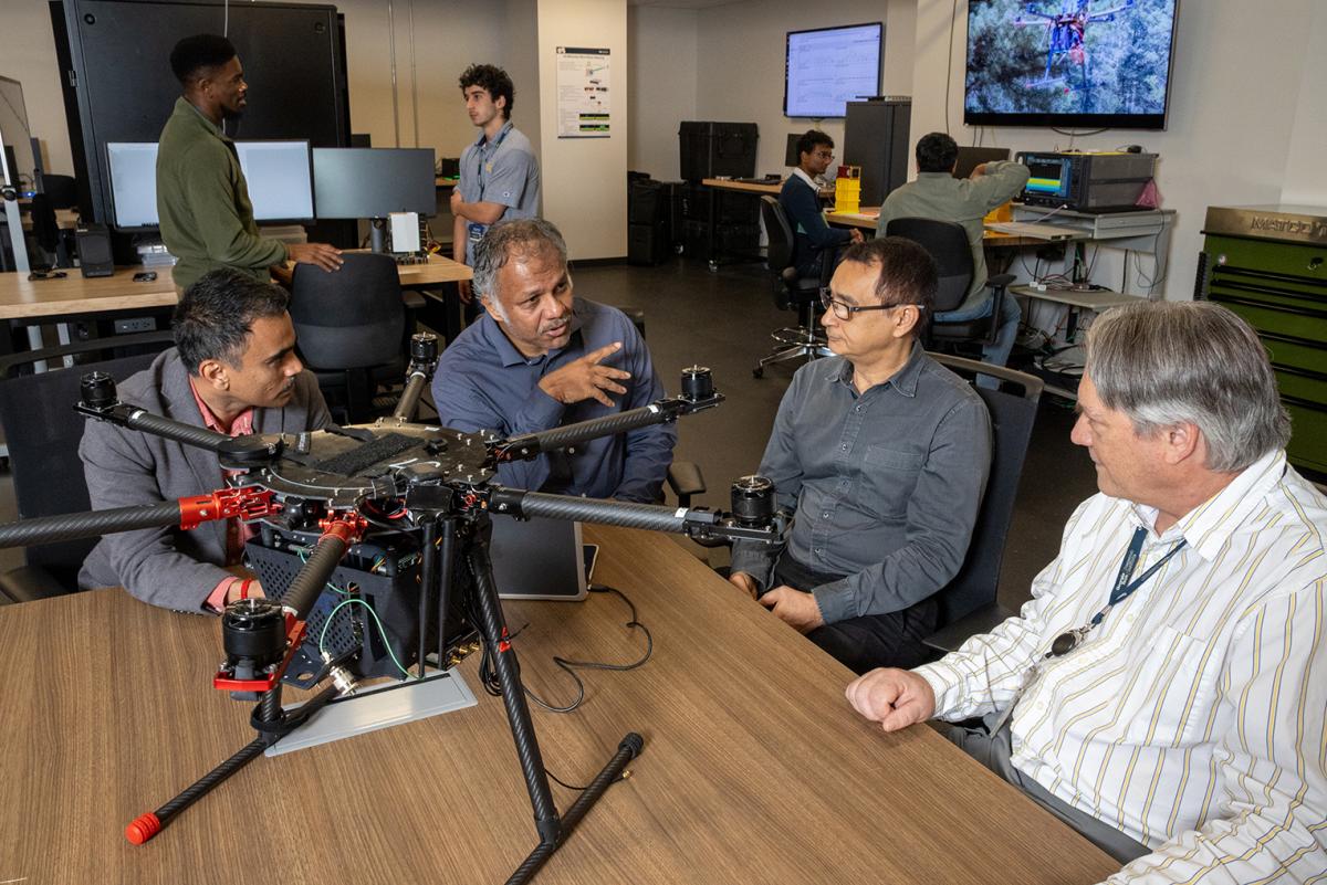 Researchers talking around a drone