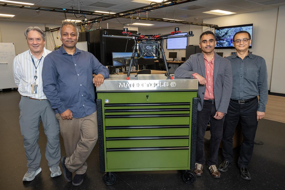 CWI researchers posing in a lab with a drone