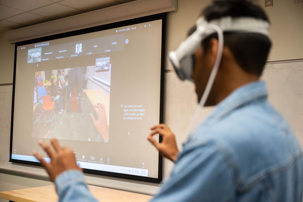 Rajgure demonstrating on a projection screen what their spatial computing product looks like from the vantage point of the Apple Vision Pro wearer.