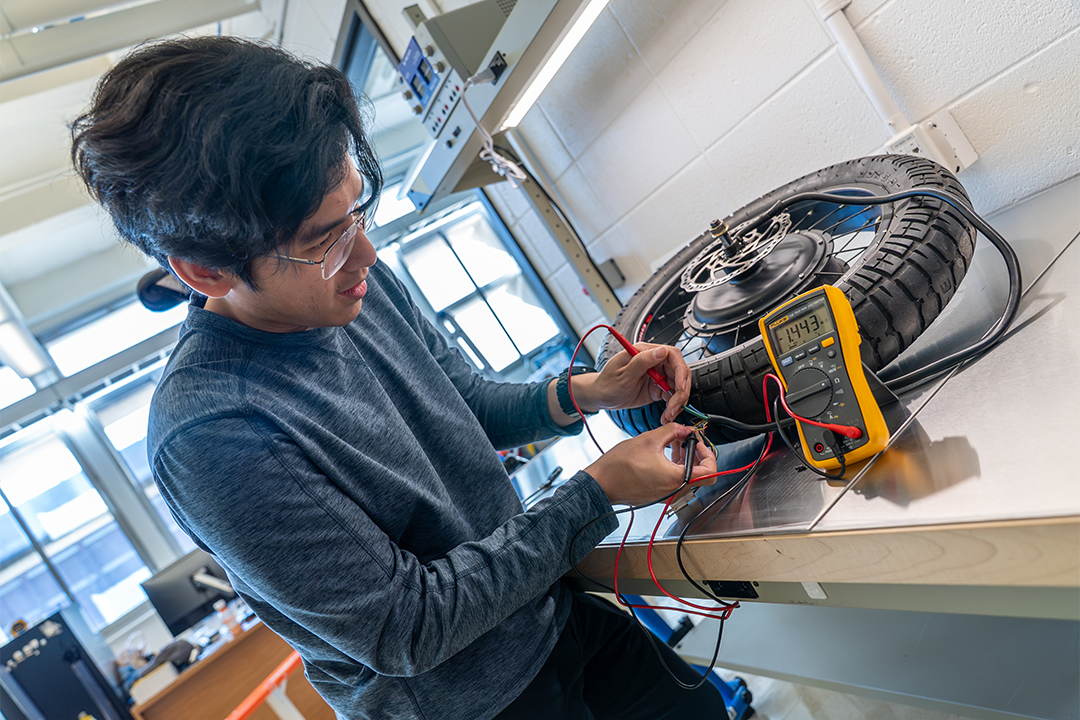 Peter Chen tests a component on an electric bike as he learns the mechanical skills needed to build his own.