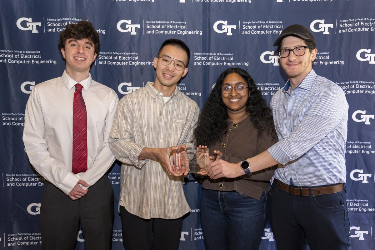 Four Ph.D. students in front of an ECE backdrop holding an award in place of the winner, their Ph.D. advisor.