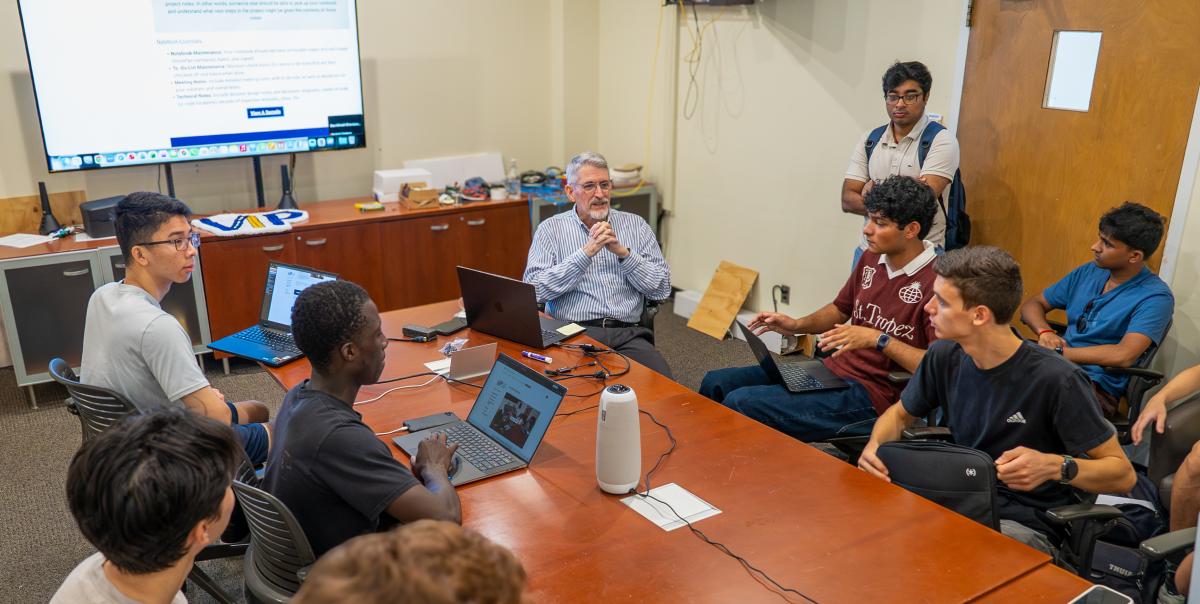Ed Coyle leading a group of students at a table discussing his VIP course.