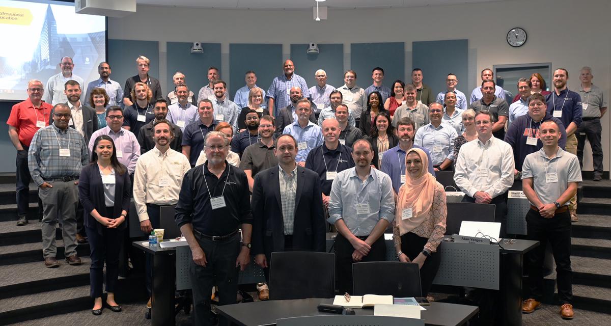 Photo of The NEETRAC advisory board meeting on the Georgia Tech campus on May 17 with new NEETRAC Director Joe Hagerman in the front. There are about 50 people in the photo taken in a modern lecture hall.